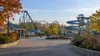 Empty amusement park midway with a roller coaster and water slides on a quiet autumn morning
