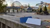 Two blank admission cards rest above a quiet amusement park with a wooden coaster and water slides in early autumn.