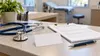 Illustrative clinic intake desk with a stethoscope, blank health-insurance card and generic eligibility forms under soft daylight.