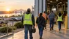 Workers enter a modern light-industrial workplace at the start of a shift.