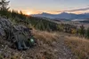 Compound bow, backpack and binoculars overlooking Montana foothills at dawn