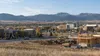 Construction activity near commercial and health-care buildings at the edge of a Montana city