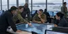 Military planners coordinate transatlantic operations in a generic command center overlooking a harbor.