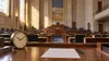 A blank ballot and clock on a wooden desk in a quiet legislative chamber