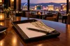 A blank restaurant receipt, pen and cash tip on a tray overlooking the Las Vegas skyline