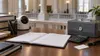 A campaign-finance ledger, calculator, security camera and locked cash box sit on a desk inside a civic building.