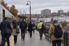 Commuters walk along a suburban New Jersey rail platform on an overcast autumn morning.