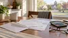 Medical bills, an open envelope, a calculator and eyeglasses on a sunlit kitchen table