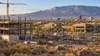 Construction activity amid commercial buildings in New Mexico’s high-desert landscape.