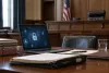Photorealistic courtroom scene with a laptop showing abstract privacy and cybersecurity symbols.