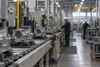 Metal components move along an assembly line inside a modern New York factory.