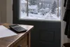 Conceptual editorial image of a blank utility bill and calculator beside a snowy New York neighborhood.