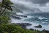 Wind-driven rain and rough surf along a volcanic Hawaiian coastline under dark storm clouds
