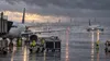Passenger jets and ground crews operate on a rain-soaked airport tarmac during a Northeast nor’easter.