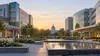 Two modern hospital buildings across a landscaped civic plaza in North Carolina.