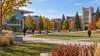 Students cross a North Dakota college campus quadrangle in early autumn.