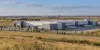 A generic distribution and light-manufacturing complex beside open prairie, illustrating North Dakota commercial activity.