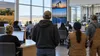 Workers in a modern public workforce center with generic agriculture, industry and technology cues.