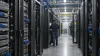 A data-center operations engineer inspecting unbranded server racks in a modern facility.