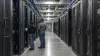 Technicians inspect server racks inside a large artificial-intelligence data center.