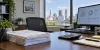 An administrative office desk with anonymized benefit forms, calculator and data display