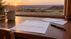 A blank registration form, envelope and pen on a desk overlooking an Oklahoma prairie.