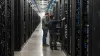 Technicians inspecting rows of unbranded servers in a large data center