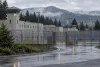 Illustrative view of a generic Oregon correctional facility behind perimeter fencing on a rainy morning