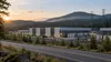 Modern data center buildings beside utility lines and evergreen hills in Oregon