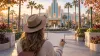 Editorial image of a theme-park visitor holding a blank sketchbook outside an animation-inspired pavilion