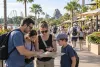 Illustration of a family reviewing a park map and phone on an unbranded Central Florida resort promenade