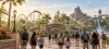 Visitors walk toward a generic Central Florida theme park in warm morning light