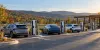 Generic electric vehicles charging at an unbranded public station in Pennsylvania's autumn hills.