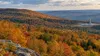 Autumn forest across a Pennsylvania ridge with a distant natural-gas well pad
