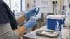 A healthcare worker prepares a vaccine syringe in a community clinic.