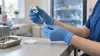 A public-health nurse prepares a vaccination syringe in a clean community clinic.