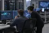 Civilian cybersecurity analysts monitor network activity in a secure operations center.