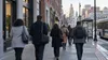 Workers walk toward offices and businesses along a Providence streetscape during the morning commute.