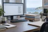 Conceptual government office desk with an abstract payroll grid on a monitor and folders beside a clock.