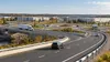 Illustrative aerial view of new highway ramps and a roundabout serving an industrial business park in early autumn