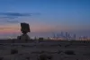 Air-surveillance radar overlooking the Riyadh skyline at blue hour.