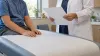 An anonymous child sits in a generic pediatric clinic while a clinician holds a blank sheet during an assessment.