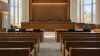 Illustrative view of an empty university law-school courtroom prepared for a five-justice appellate session.