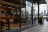 A closed, unbranded urban coffeehouse with chairs stacked on tables at dawn