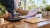 An illustrative view of a Florida worker reviewing a timesheet with a calculator at a small-business counter
