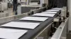Plain sealed envelopes move through a generic mail-sorting facility