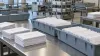 Blank sealed envelopes arranged in sorting trays on a mail-processing table