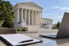 The U.S. Supreme Court building behind an unmarked voter-registration checklist and laptop