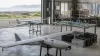 Unbranded fixed-wing reconnaissance drones and quadcopters on maintenance stands in a coastal technology hangar
