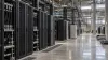 Rows of unbranded liquid-cooled AI server racks in a large data center under construction
